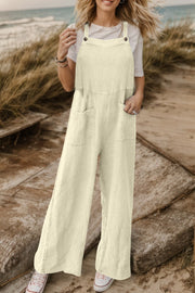 Cream textured cotton overalls with square pockets and wide legs.