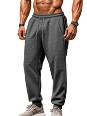 Gray joggers with black athletic stripes on the side, drawstring waist, and cuffed ankles.