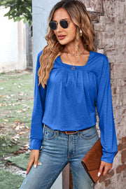 Blue long sleeve top with square neckline and pleated detail