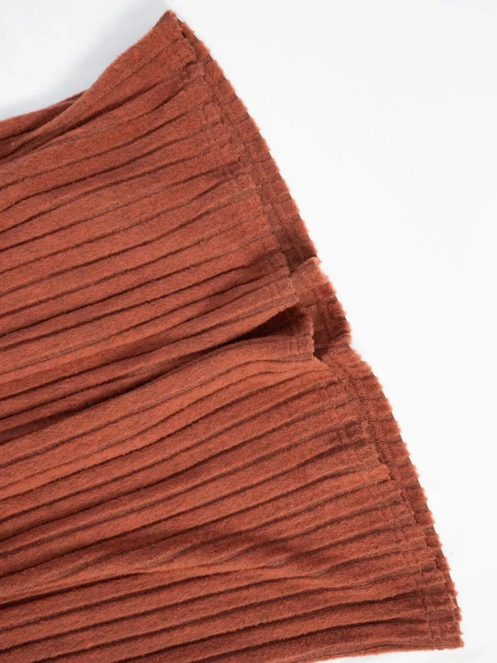 Ribbed knit A-line dress in rust with long sleeves, close-up detail of fabric texture.