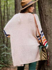 Beige knit duster cardigan with rainbow striped sleeves and a relaxed fit.