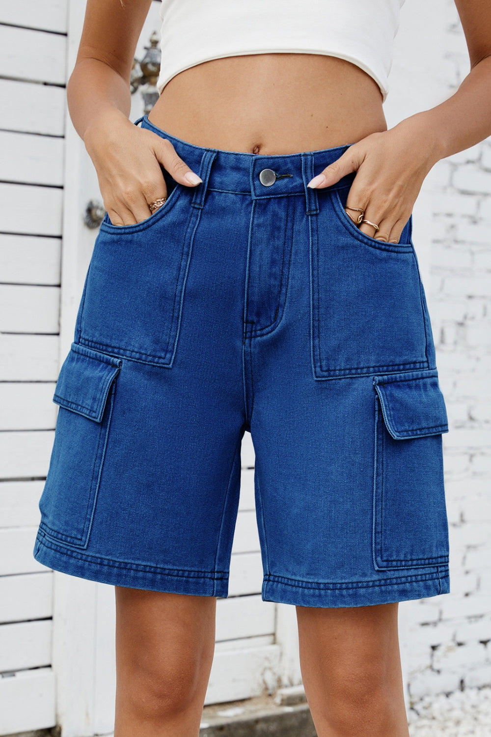 Medium wash denim utility shorts with large cargo pockets and contrast stitching.