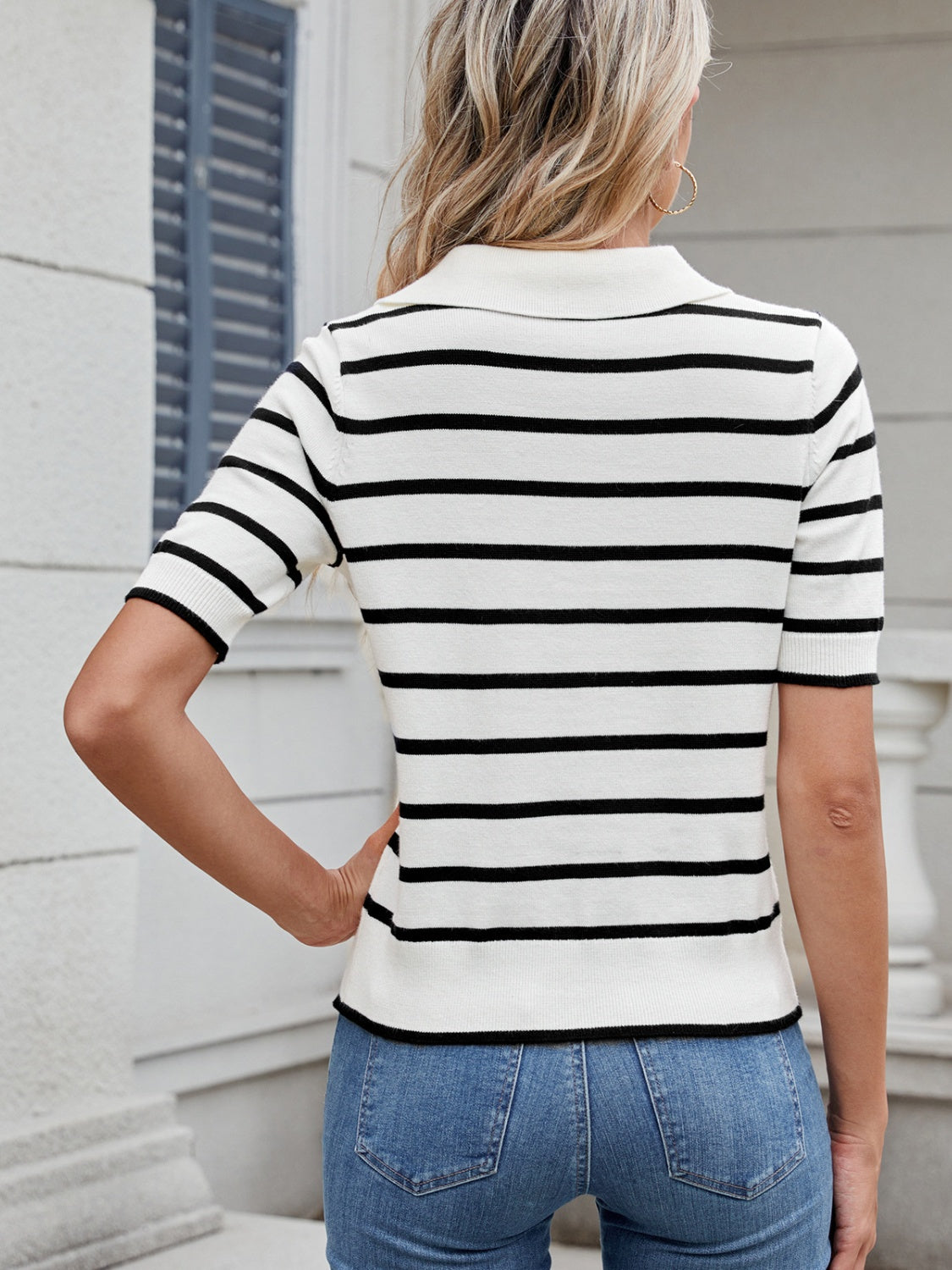 Nautical stripe knit polo top in black and white with a collar and short sleeves.