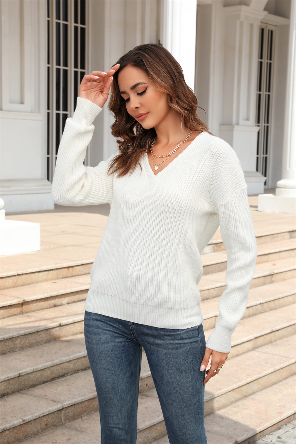 White ribbed knit V-neck sweater with long sleeves, casual fit.
