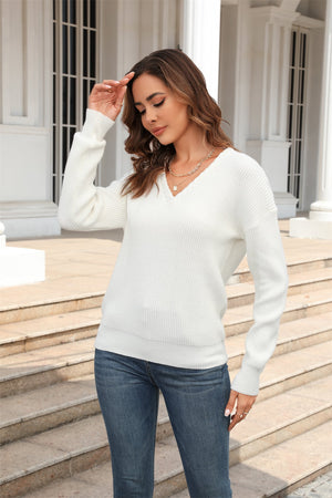 White ribbed knit V-neck sweater with long sleeves, casual fit.