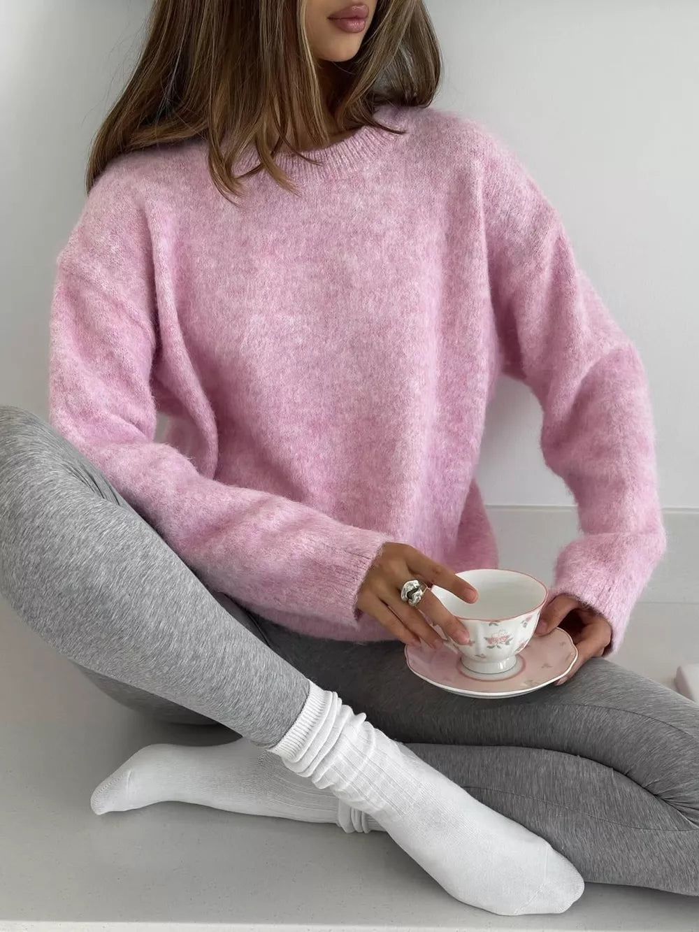 Pink cozy knit sweater with relaxed fit and crew neck.