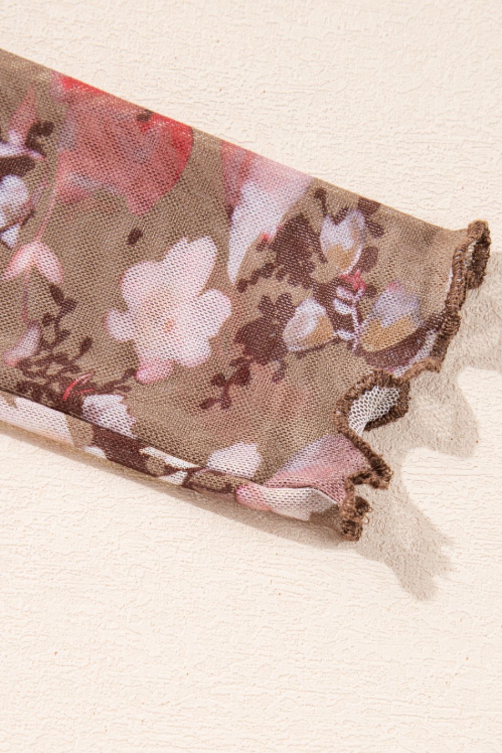 Sheer floral mesh blouse with lettuce edge cuff in floral cream.