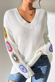 White knit sweater with colorful granny square sleeve details and V-neck.