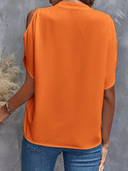 Open-shoulder tangerine blouse with short sleeves and a keyhole neckline detail.