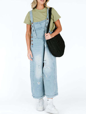 Light blue ripped relaxed fit denim overalls with adjustable straps and button details.