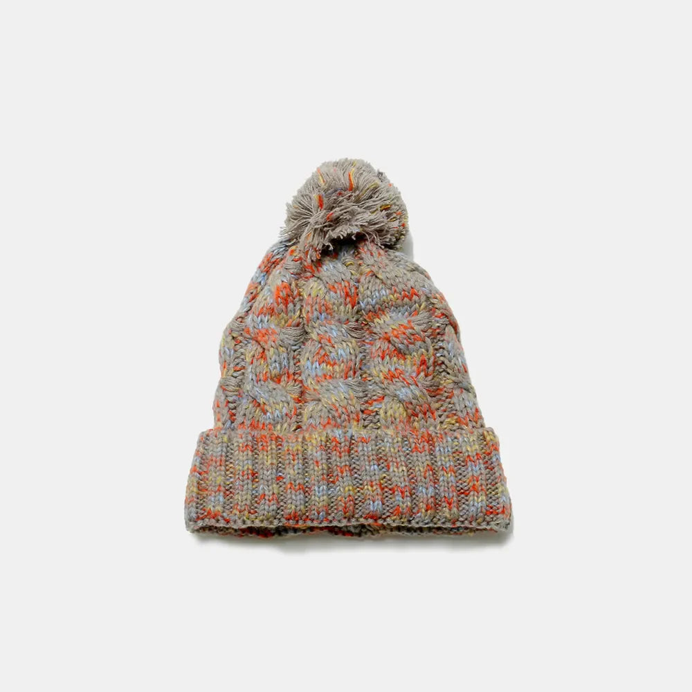 Textured knit beanie with pom in multi-color marled yarn and cable knit pattern.