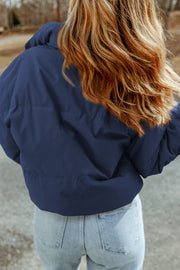 Padded crop jacket in cobalt blue with stand collar, shown from the back.
