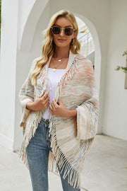 Textured stripe fringe cape in a multi-color knit with fringe trim.