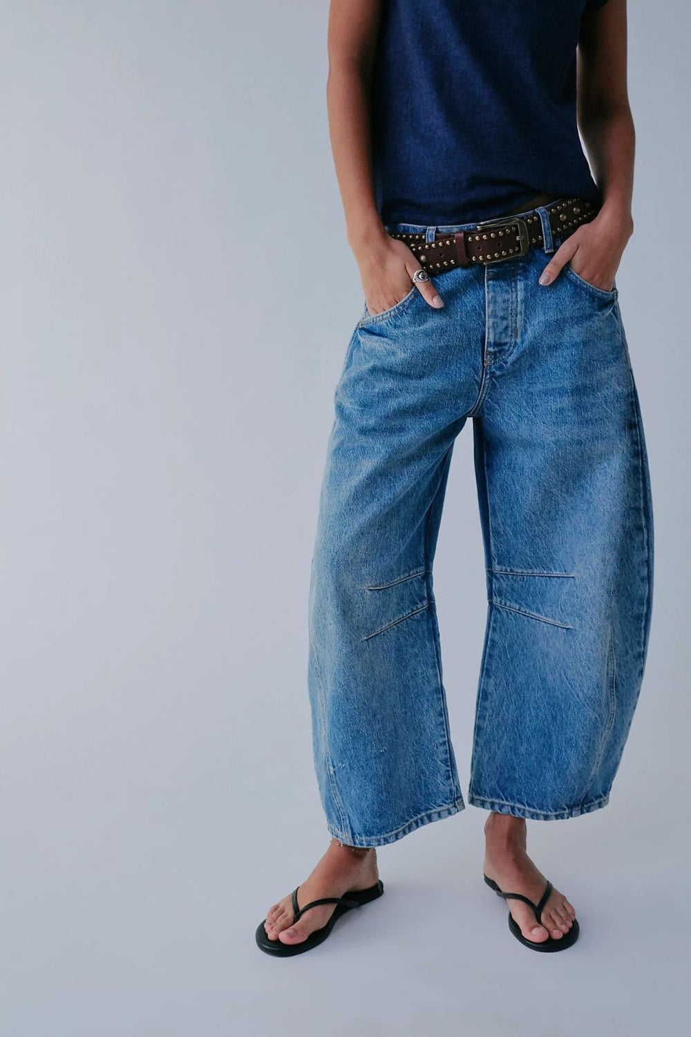 Light blue denim barrel leg jeans with button fly and paneled knees.