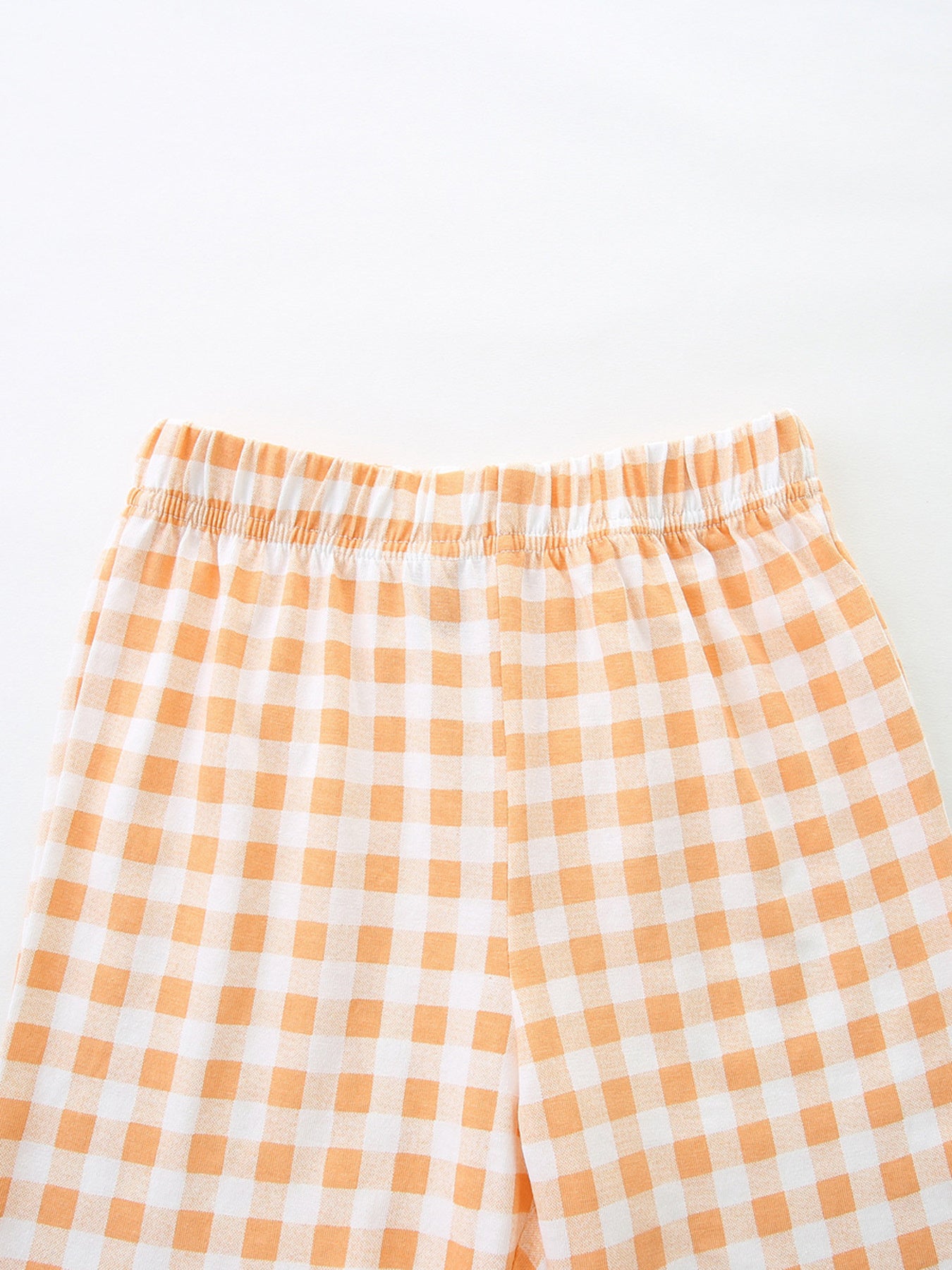 Toddler shorts with elastic waistband in orange and white gingham cotton.