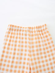 Toddler shorts with elastic waistband in orange and white gingham cotton.