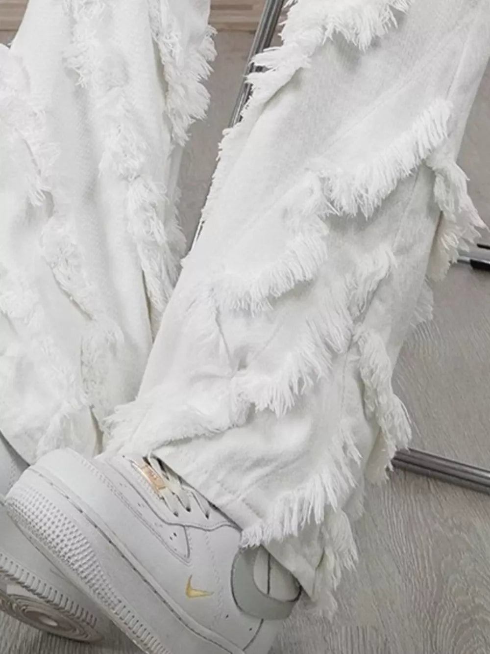 White wide-leg jeans for men with layered fringe detailing.