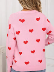 Pink acrylic knit sweater with a red heart print, crew neck, and long sleeves.