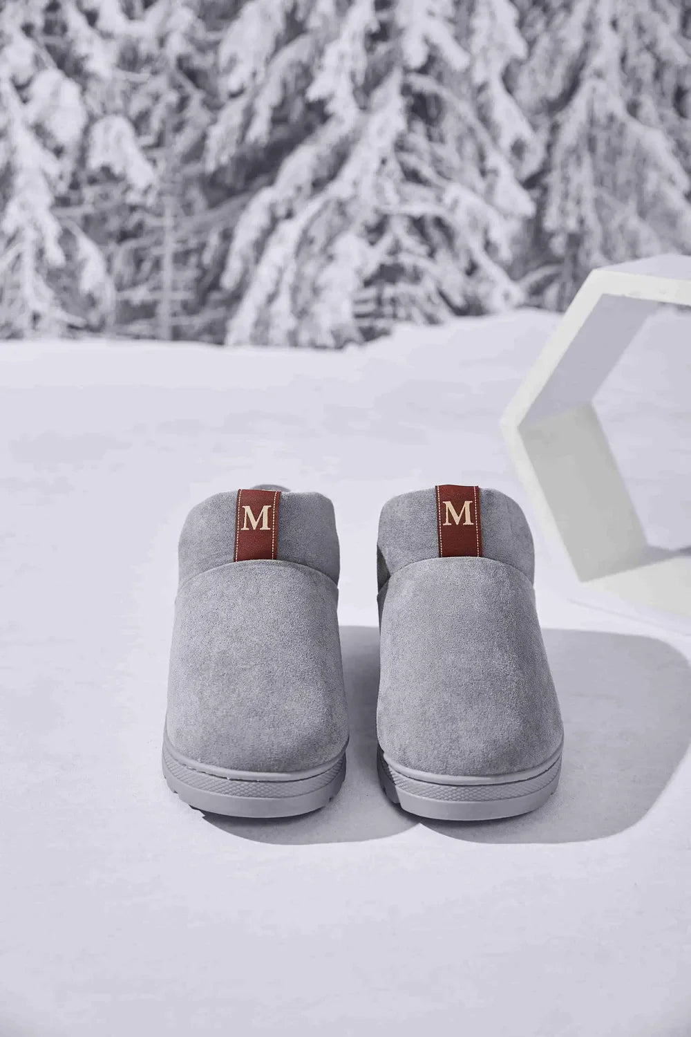 Gray suede house booties with shearling lining and maroon pull tabs.