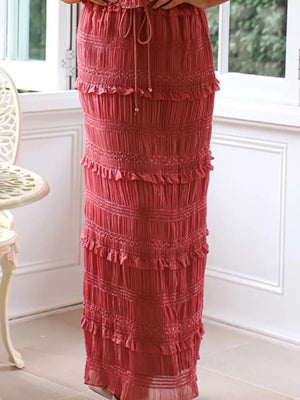 Brick-red maternity swim dress with smocked tiers and ruffled details.