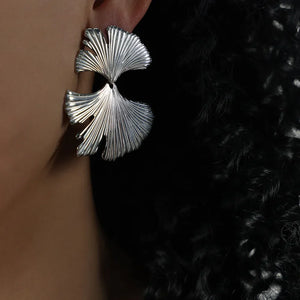 Silver Ginkgo leaf statement earrings with detailed veins, worn by a model.