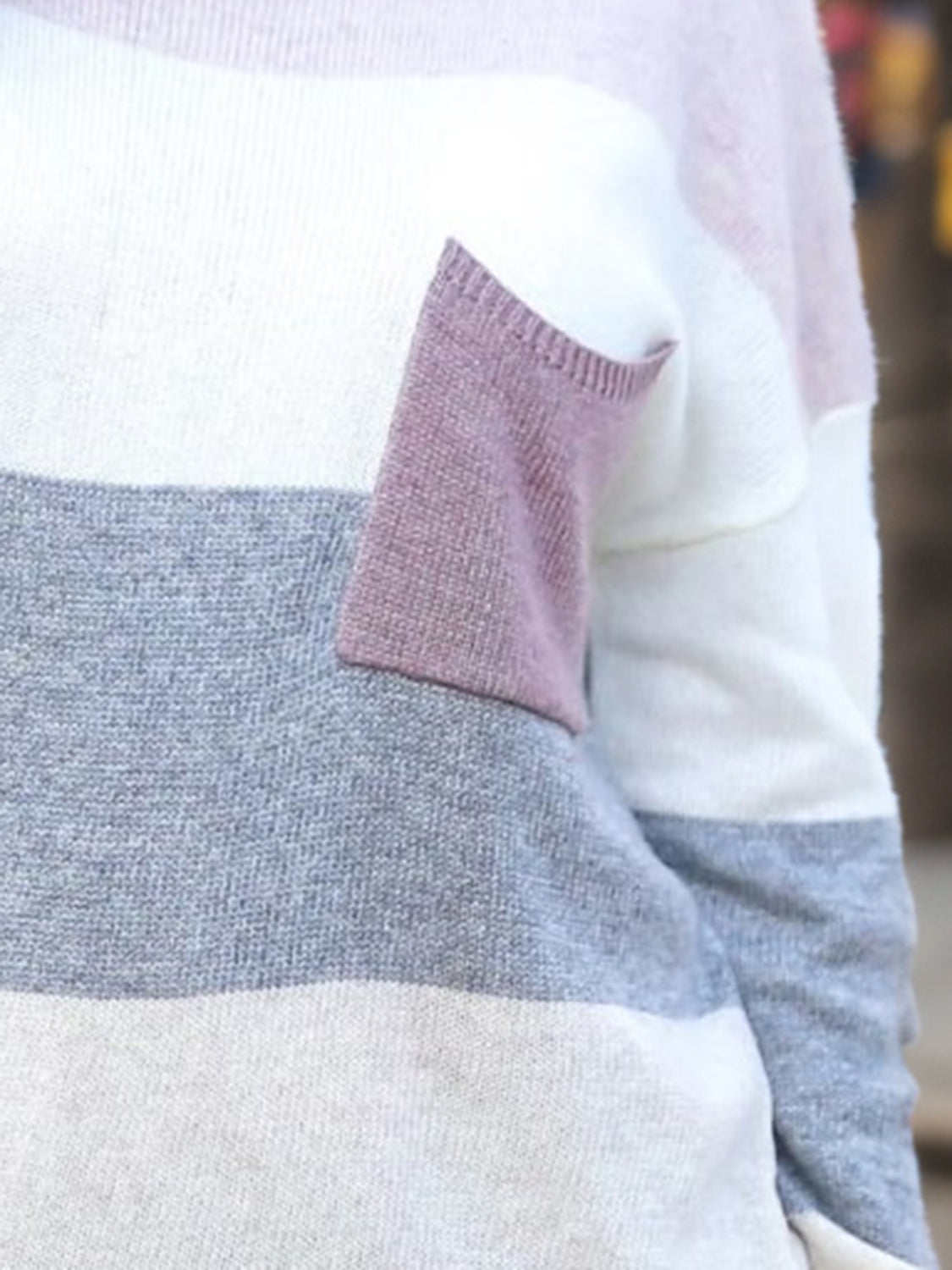 Colorblock knit sweater with a contrast pocket in stripe pattern.