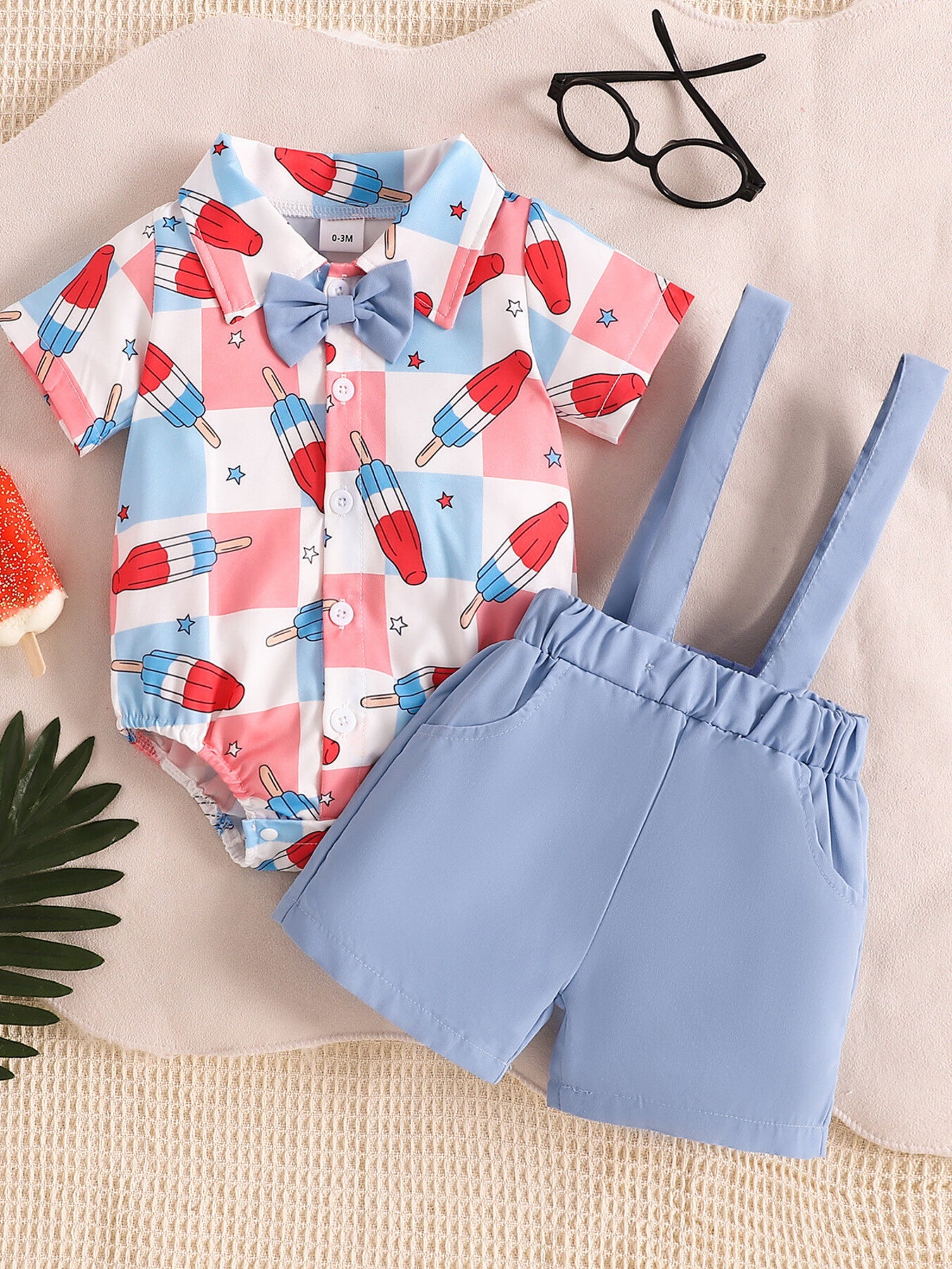 Baby bodysuit and suspender shorts set with popsicle print, blue bow tie, and light blue shorts.