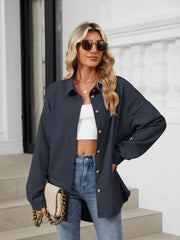 Oversized corduroy shirt jacket in Dark Navy with button front and collar, styled with a white crop top and jeans.