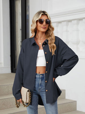 Oversized corduroy shirt jacket in Dark Navy with button front and collar, styled with a white crop top and jeans.
