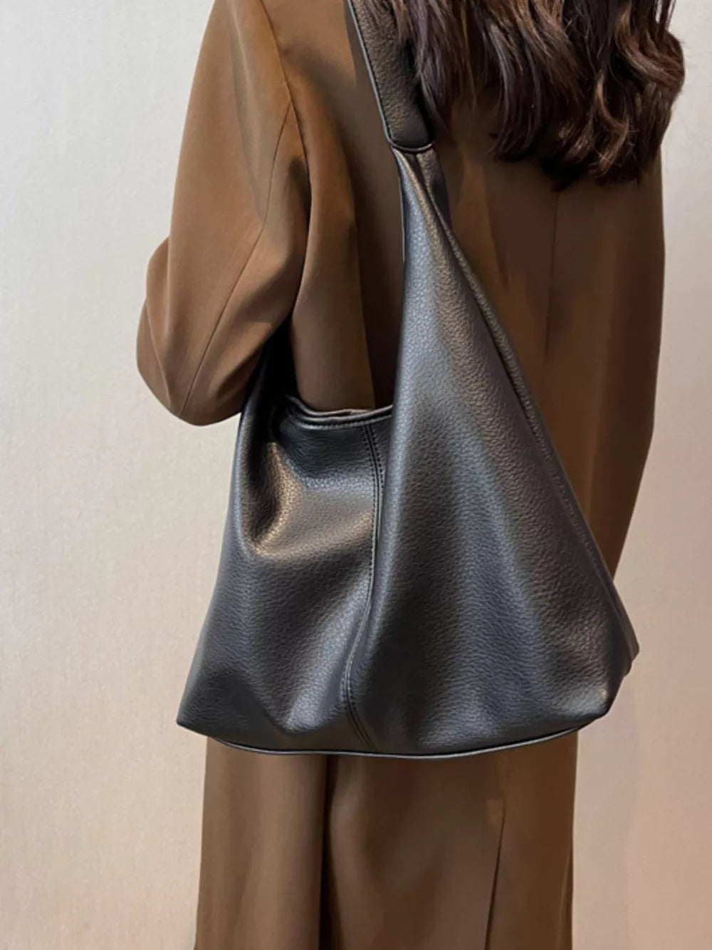 Black pebbled leather hobo shoulder bag with a slouchy silhouette.