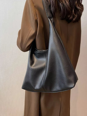 Black pebbled leather hobo shoulder bag with a slouchy silhouette.