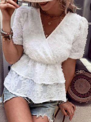 White textured surplice blouse with tiered peplum and short puff sleeves.