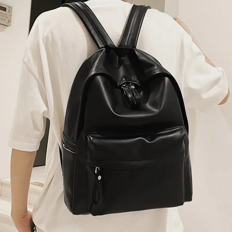 Black leather backpack with front pocket and tassel zipper detail