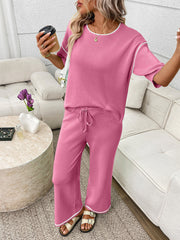 Fuchsia pink loungewear set with crew neck top and drawstring pants, white piping detail