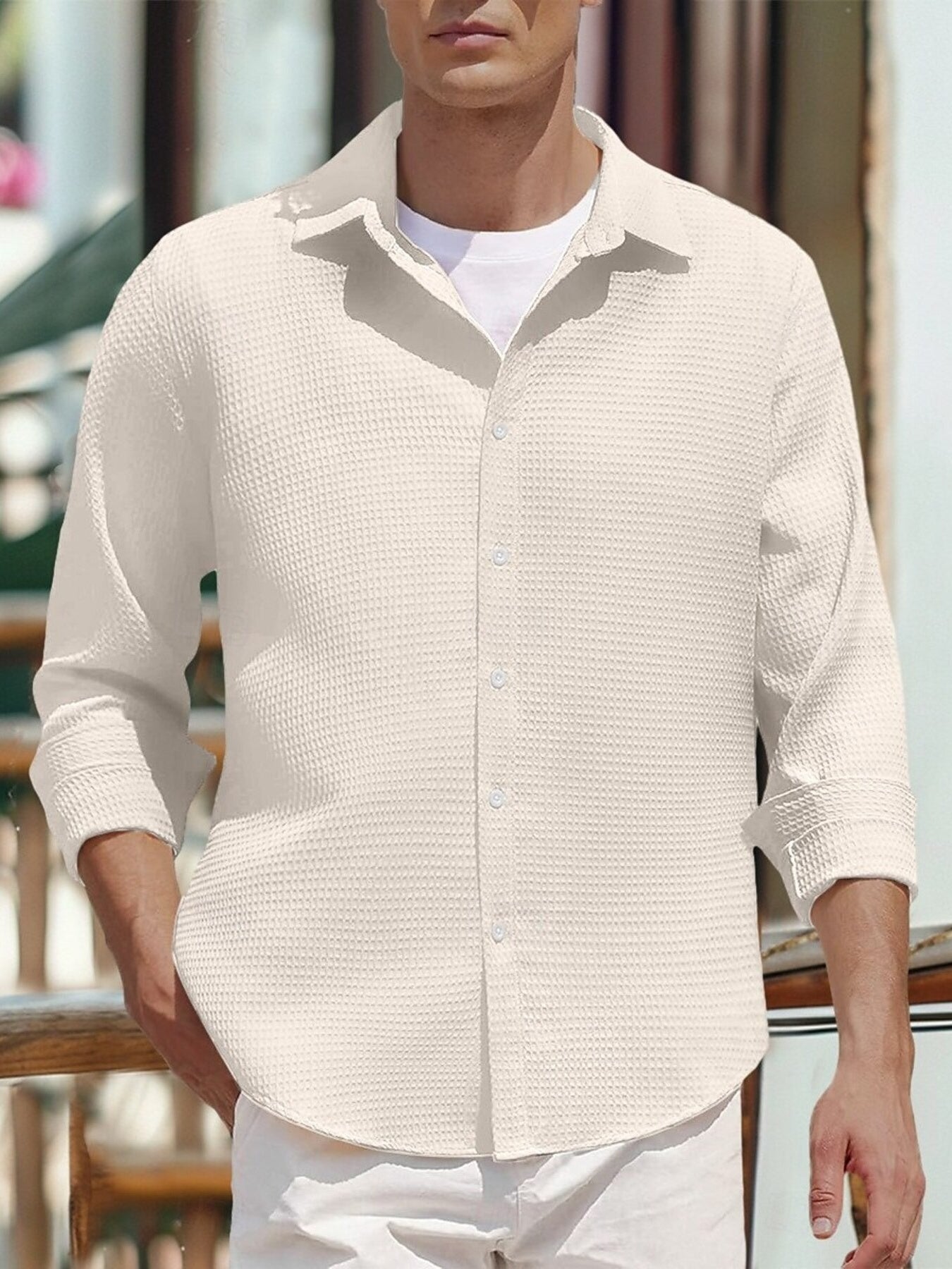 Men's white waffle knit button-up shirt with rolled sleeves.