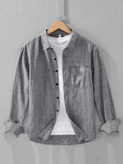 Grey textured linen long sleeve button-up shirt with a chest pocket, worn over a white tee.