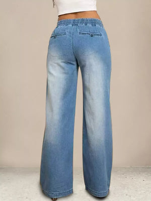 Light blue denim maternity jeans with wide legs and drawstring waist.