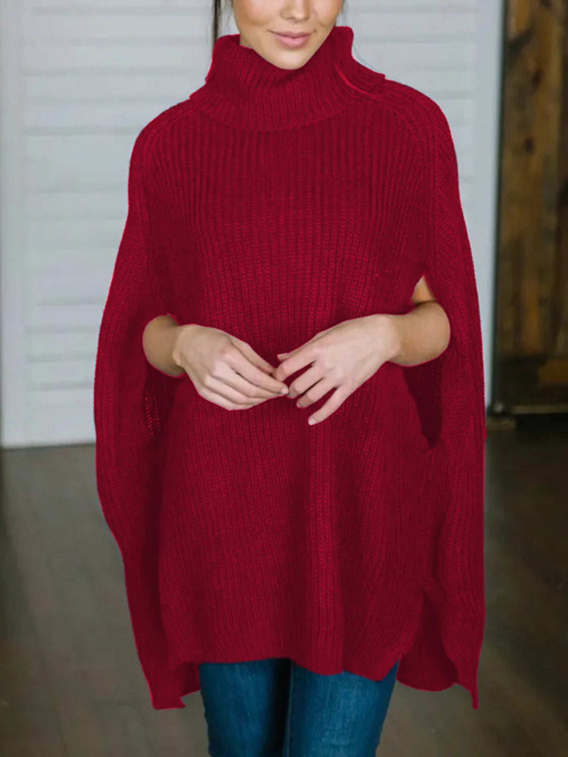 Red acrylic turtleneck sweater with cape sleeves and ribbed texture.