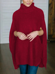 Red acrylic turtleneck sweater with cape sleeves and ribbed texture.
