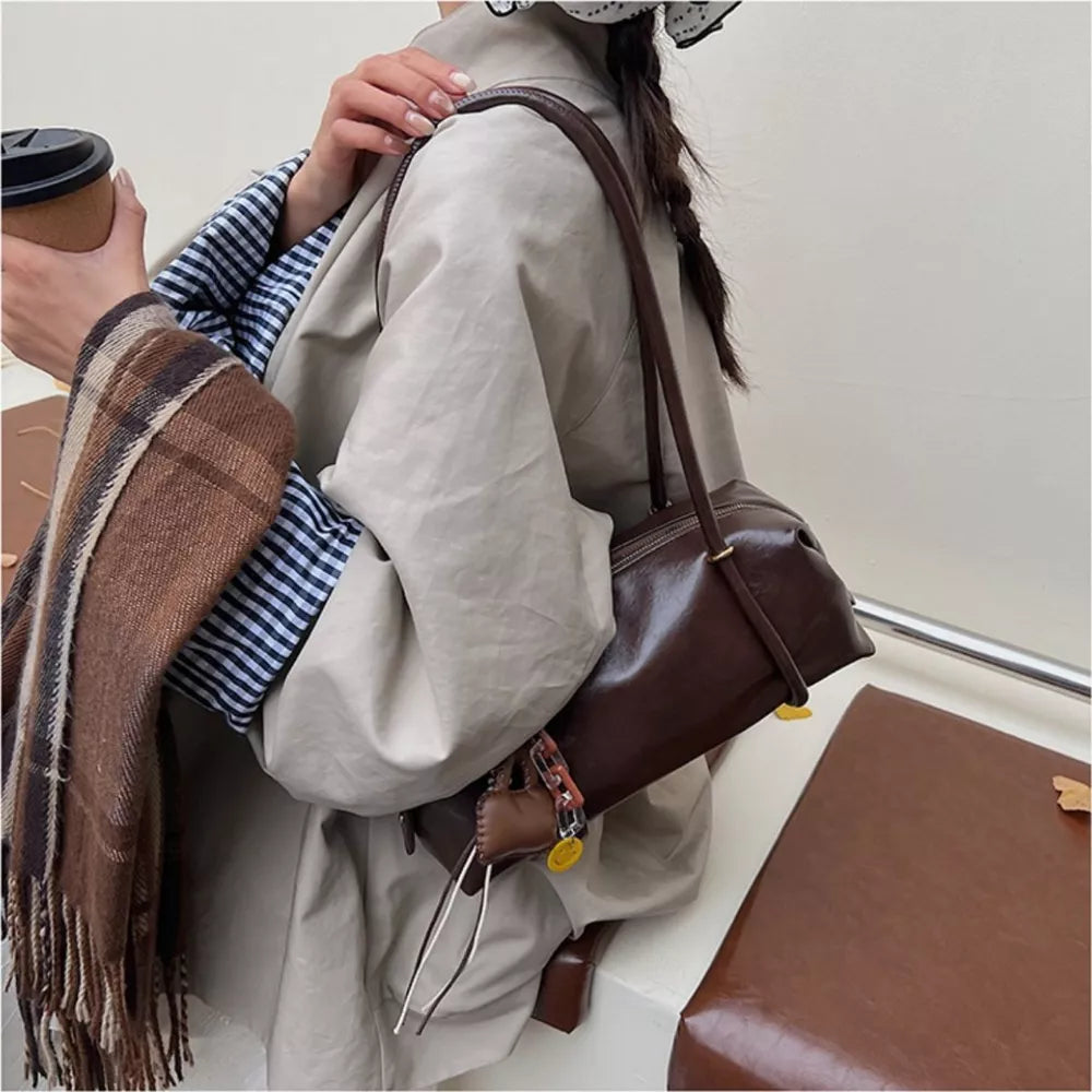 Chic brown pu leather shoulder bag with charm detail.