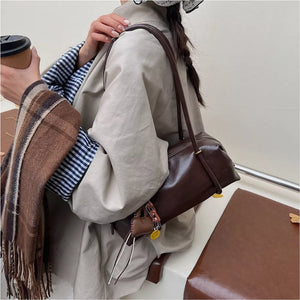 Chic brown pu leather shoulder bag with charm detail.