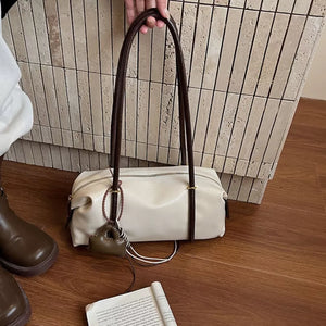 Chic ivory pu leather shoulder bag with dark brown straps and a small charm.