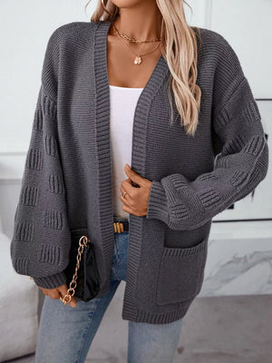 Dark gray chunky knit open-front cardigan with pockets and textured sleeves.