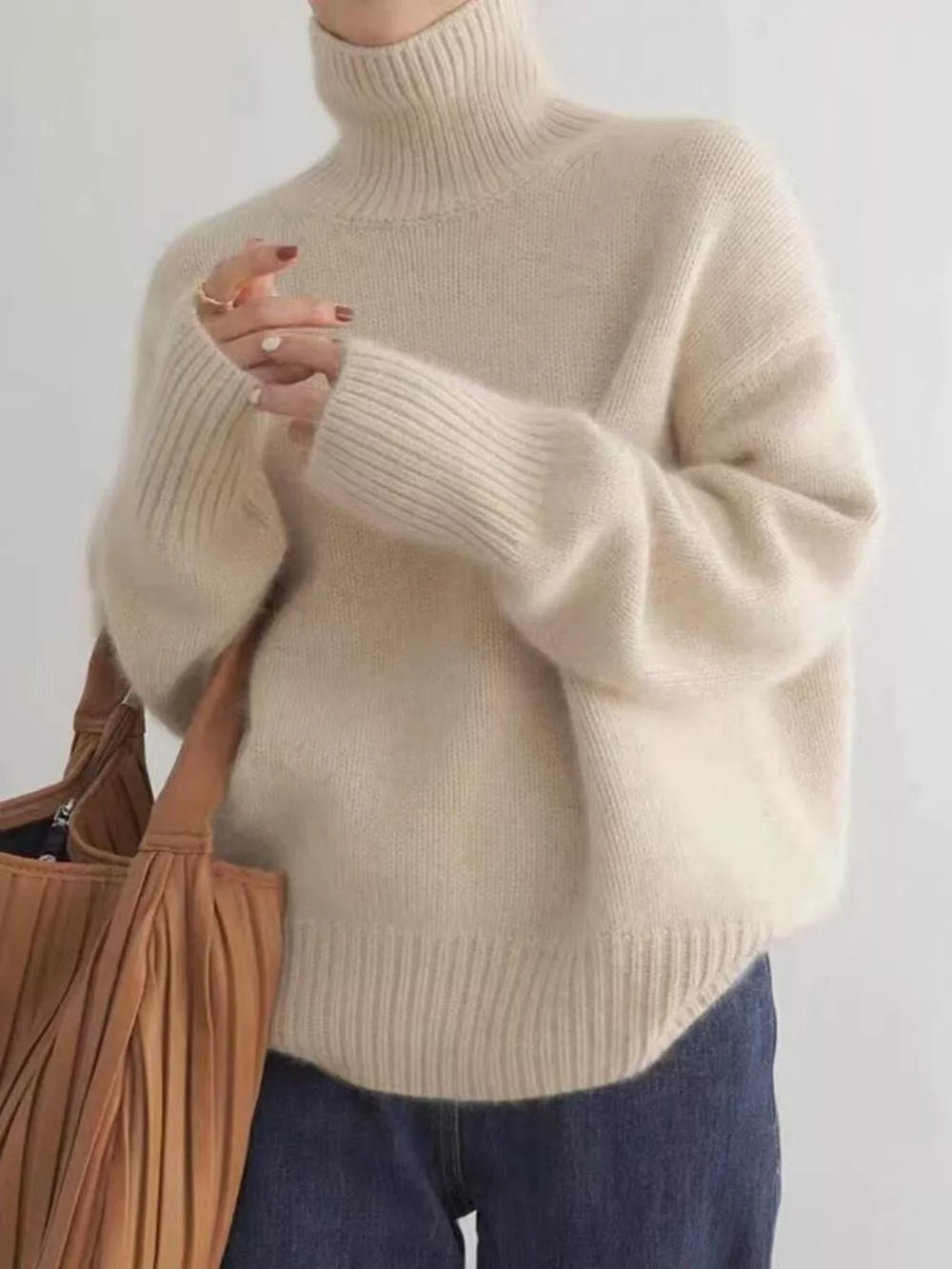 Cozy apricot acrylic turtleneck sweater with dropped shoulders and ribbed cuffs and hem.