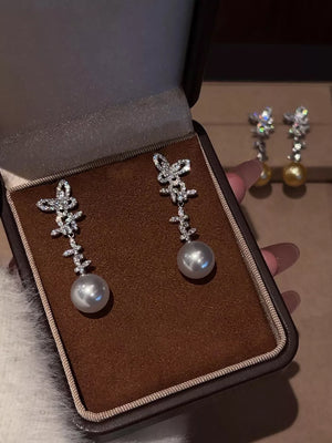 Lustrous butterfly pearl drop earrings in white with crystal accents.