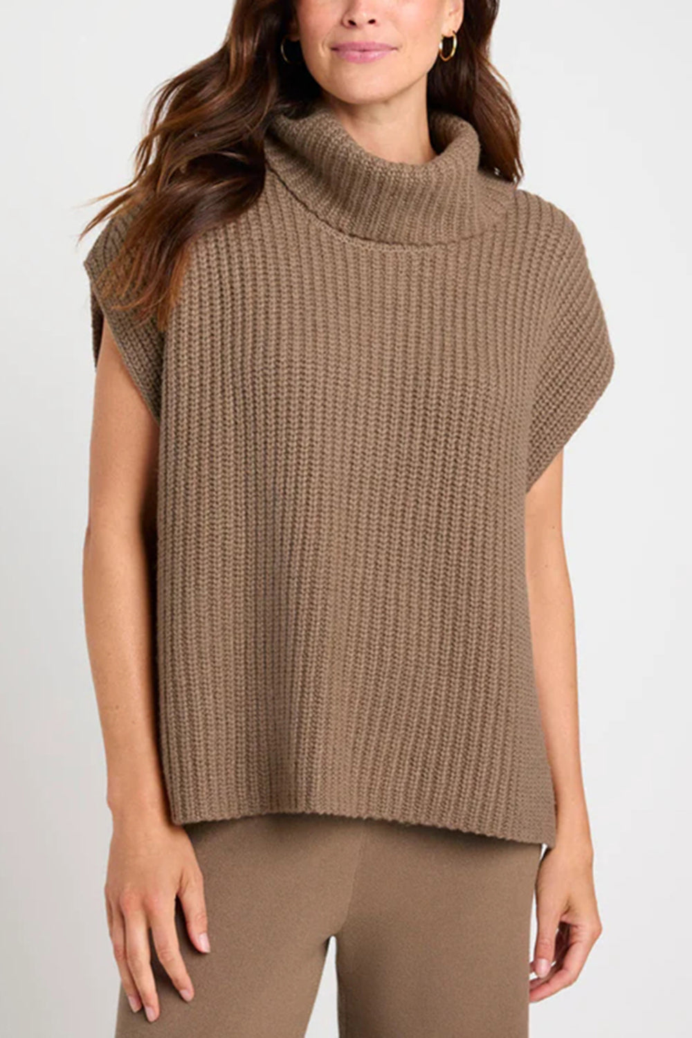 Sleeveless ribbed turtleneck sweater in taupe acrylic, styled casually.