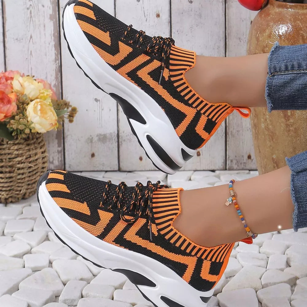 Geometric knit platform sneakers in orange and black with white soles.