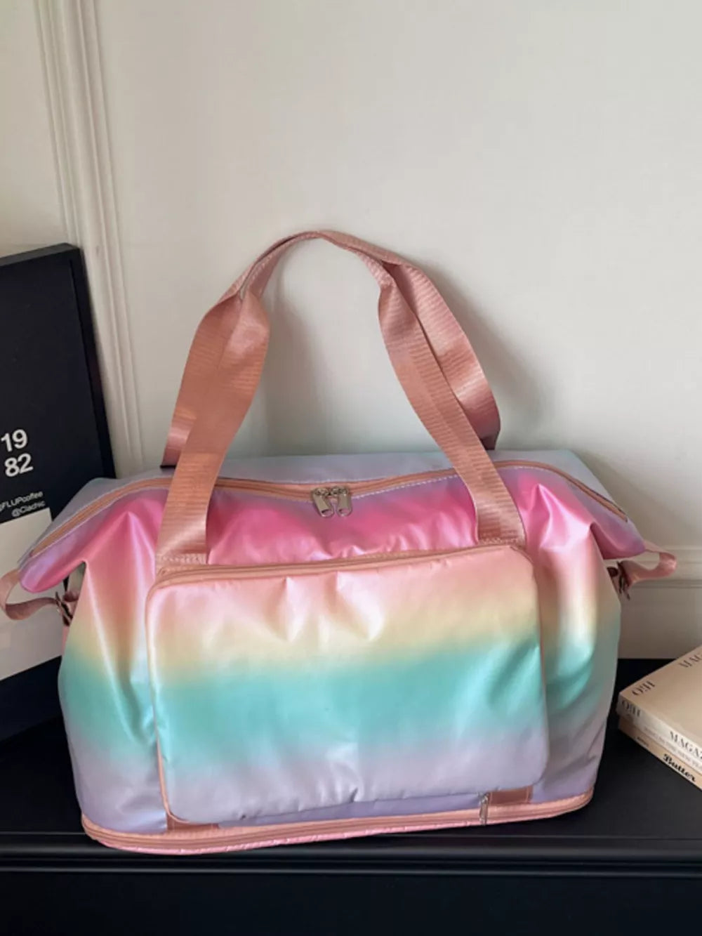 Iridescent gradient large duffel bag with pink straps and front pocket.
