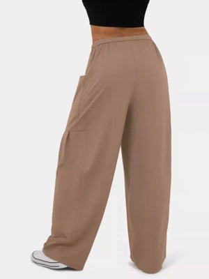 Tan wide-leg jeggings with cargo pockets and drawstring waist, styled casually.