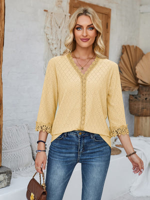 Light yellow eyelet blouse with V-neck and lace trim details.